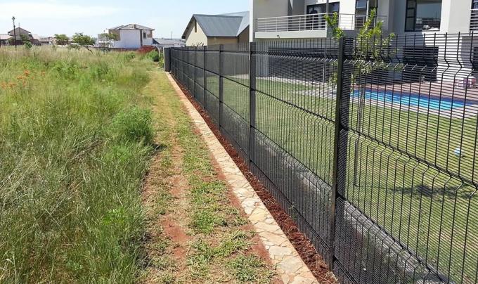 Black polyester coated high security clearvu fence for house protection, grass land and a swimming pool in yard.
